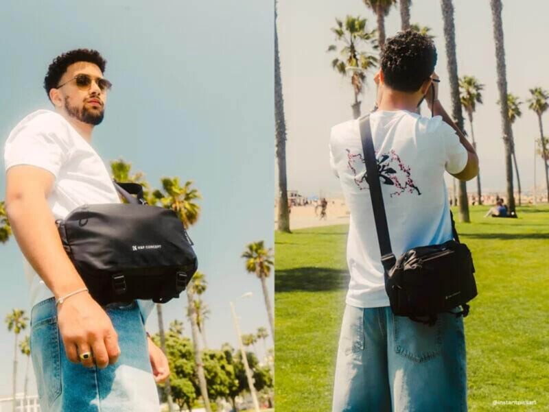 Человек с черной сумкой камеры на фоне пальм