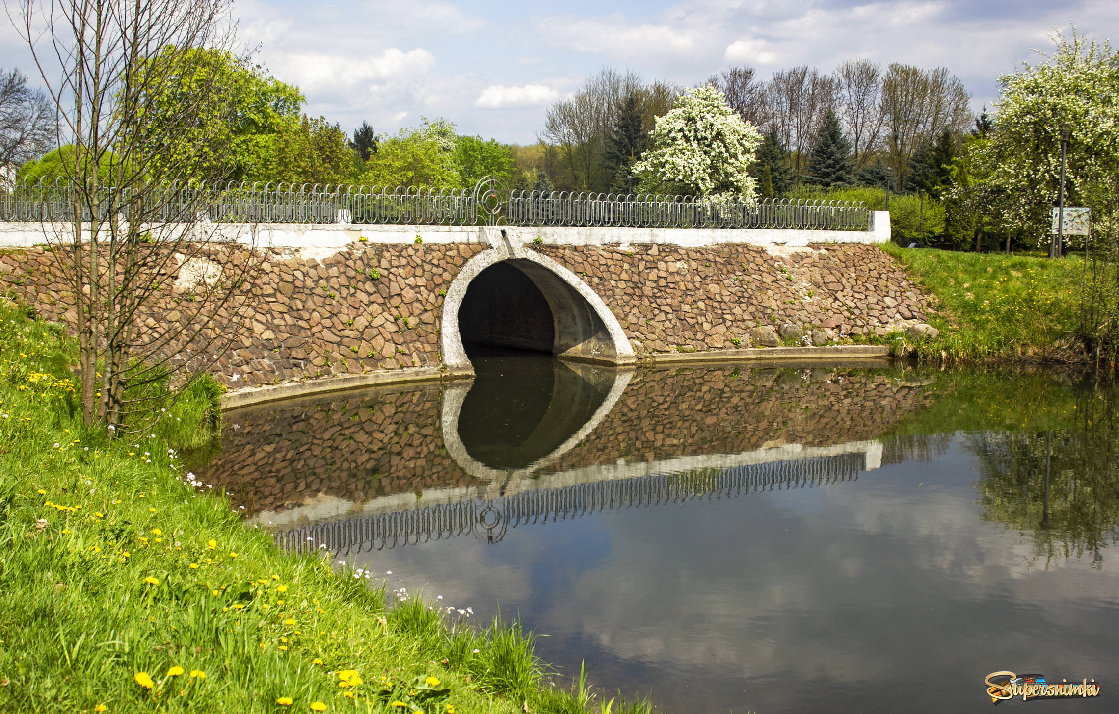 Stone bridge over the river in spring in the park