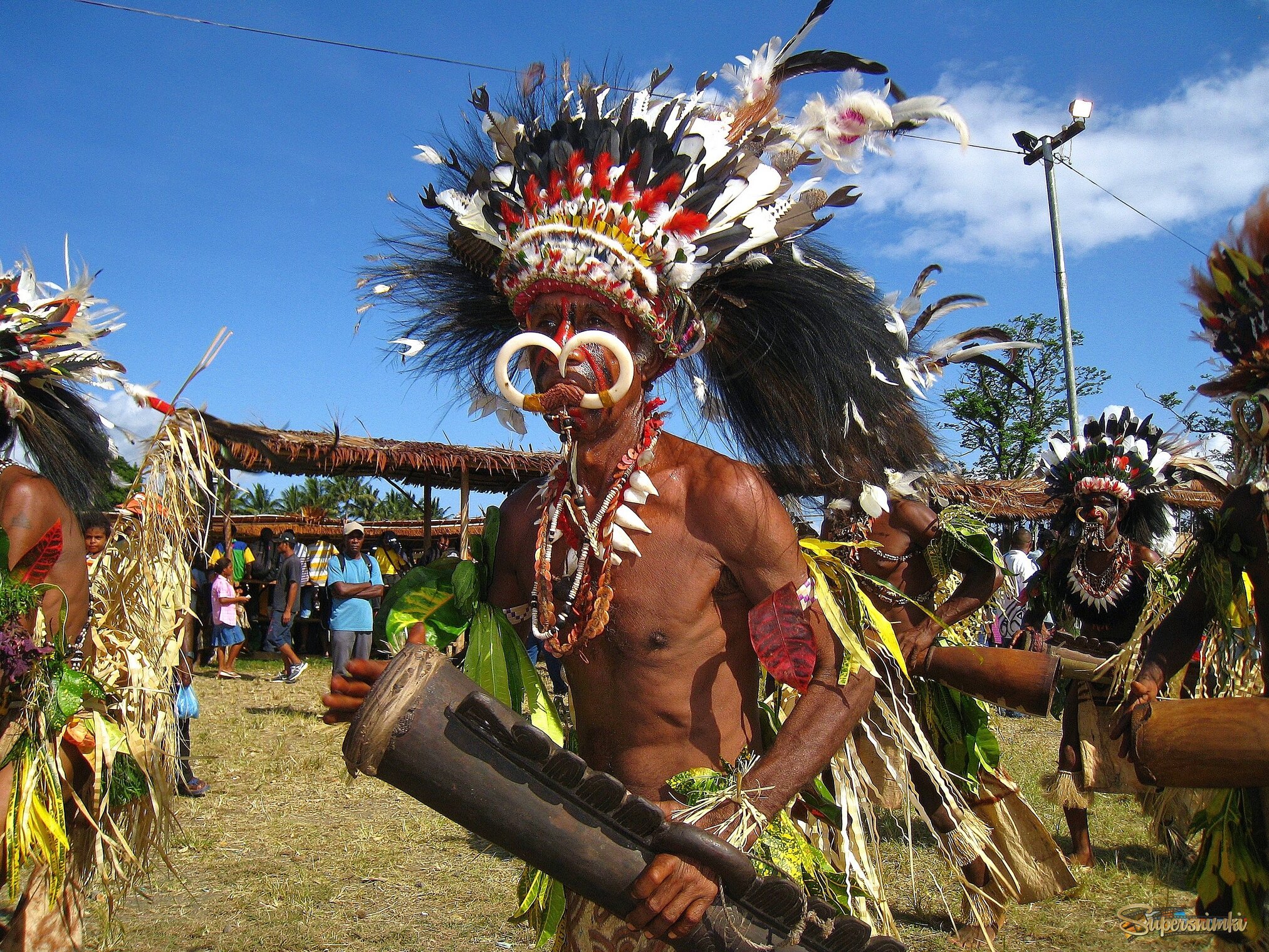 Яркий и харизматичный мужчина с барабаном и с клыками.
