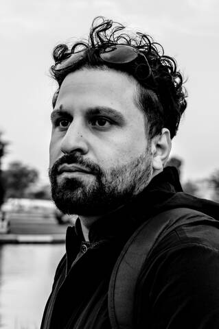 A striking, high-contrast black-and-white portrait of a man